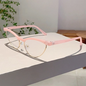 Pink cat-eye blue light glasses with semi-rimless gold metal frames on a minimalist stand