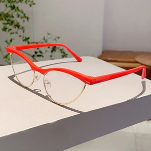 Close-up of retro cat-eye glasses with red and gold mixed metal frame on a display surface