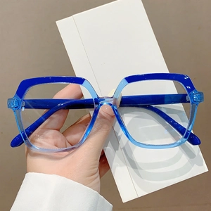 Two-tone blue block frame square glasses shown in hand against a neutral background