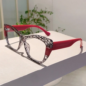 Detail shot of cat-eye glasses featuring black and white textures with red temples