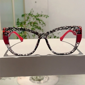 Detailed view of cat-eye glasses frame with black textured lines and red splice accents