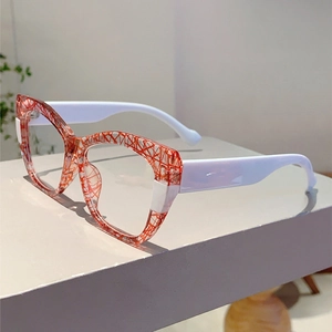 Detail view of cat-eye glasses with orange grid frames and white temples on display