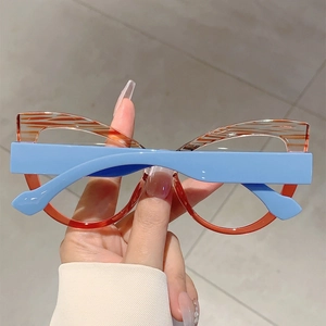Detail of cat-eye glasses frame featuring orange striped top and light blue temples