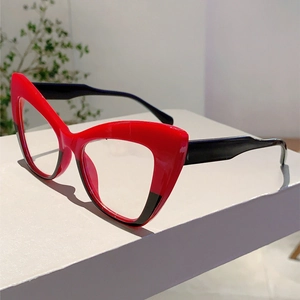 Detail of cat-eye glasses showing red and black contrast frames on a display block