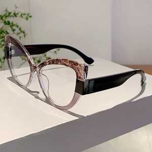 Detail of cat-eye glasses frame featuring brown tortoiseshell and pink color splicing