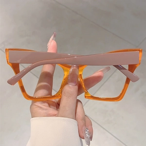 Detailed shot of large square orange transparent eyeglass frames with pink temples