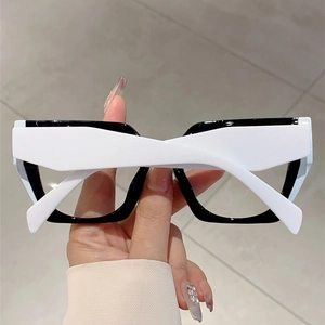 Detail of deconstructed thick square glasses with high-contrast black and white frames