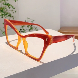 Detail of trendy cat-eye glasses frame with red gradient finish and silver rivets