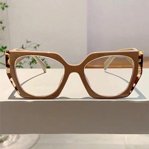 Detail of retro cat-eye glasses frame in beige with tortoiseshell temples on a white surface