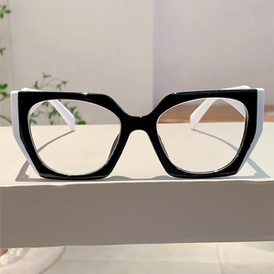 Detail of trendy black and white cat-eye glasses with metal hinges on a display stand