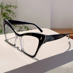 Detail of cat eye glasses frame showing black and transparent two-tone design with metal studs