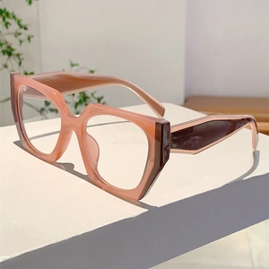 Detail of trendy polygonal glasses featuring peach pink frames and tortoiseshell temples