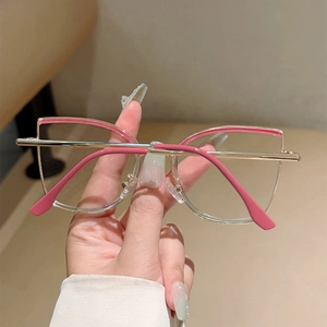 Close-up of cat-eye glasses with pink accents and golden metal frame detail