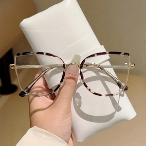 Detail of tortoise shell cat-eye glasses frame with golden metal hinges and case