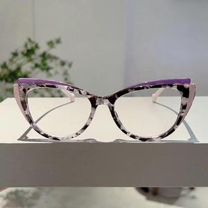 Detailed view of cat-eye glasses with purple frames and black and white patterned accents