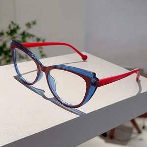 Close-up of cat eye glasses frames in red and blue color blocking on a white stand