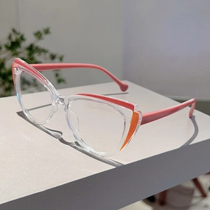Close-up of cat-eye glasses with pink and orange color blocking on a white stand