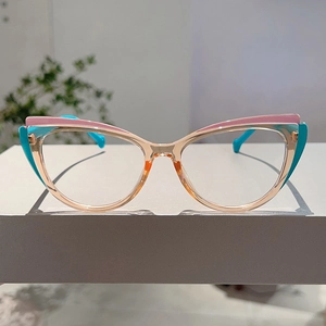 Close-up of cat-eye glasses frame with pink, cyan and champagne color block design