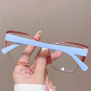 Détail de la monture rose transparente et branches bleues sur lunettes anti-lumière bleue
