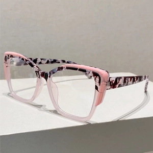 Détail de lunettes œil de chat avec motif marbre rose et branches épaisses sur un socle