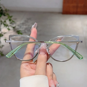 Dettaglio degli occhiali cat-eye in metallo argento con punte delle stanghette verde chiaro