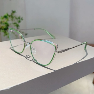 Dettaglio occhiali cat-eye con accenti verdi e aste sottili in metallo con cerniera