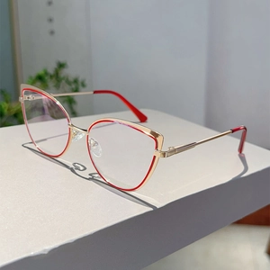 Dettaglio montatura cat-eye dorata con accenti rossi e cerniere a molla flessibili