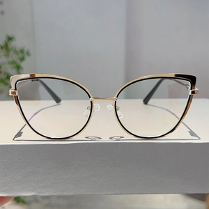 Vista macro della montatura per occhiali cat-eye con elegante finitura oro e nero