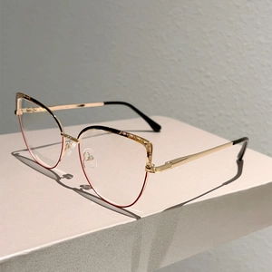 Detail view of cat-eye metal frames with tortoiseshell accents on a stone pedestal