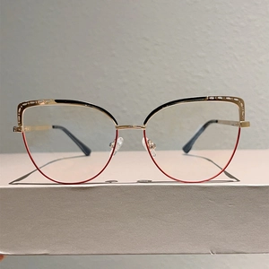 Detail view of cat-eye glasses frame with black and red splicing and golden hollow decoration