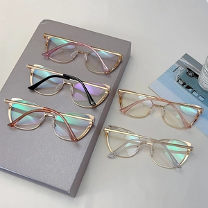 Group display of five vintage cat-eye glasses frames in assorted colors on tiered stands