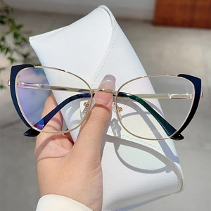 Detail of cat eye glasses in black and gold metal held with a white leather case