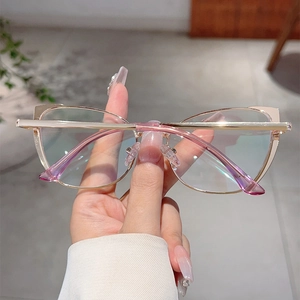 Detail of cat eye glasses with light gold metal frame and anti-blue light coated lenses