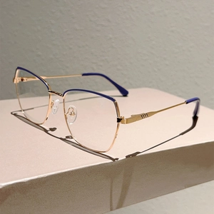 Detail view of gold and purple polygon glasses frame on a minimalist geometric stand