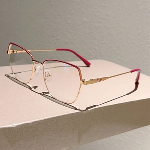 Detailed close-up of geometric metal frames with gold finish and rose red accents