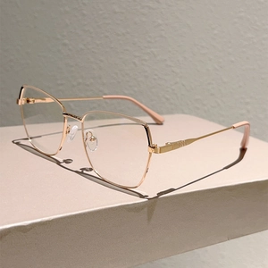 Macro detail of cat eye rose gold metal frame glasses on geometric display stand