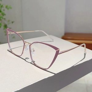 Détail de lunettes œil-de-chat avec monture rose violet et branches en métal doré