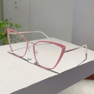 Détail d'une monture de lunettes œil de chat rose avec branches en métal doré