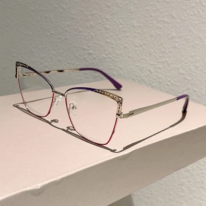 Close-up of cat-eye metal glasses frame featuring intricate hollow wavy patterns and purple accents