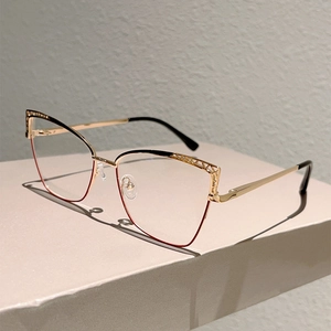 Detailed view of cat-eye glasses frame featuring gold metal and black hollow-out geometric design