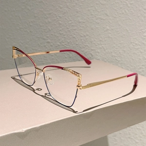 Detail of cat-eye metal glasses frame with hollow mesh design and burgundy finish