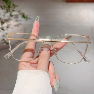 Close-up of golden metal cat-eye glasses with transparent lenses and silicone nose pads