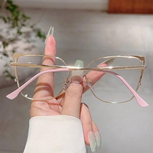 Detailed close-up of golden cat-eye metal frame glasses with pink temple tips