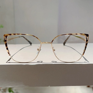 Front view of cat-eye frames with tortoiseshell top and gold metal bottom details