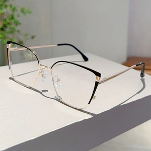 Detailed view of cat-eye glasses frame with gold metal legs and black contrast accents