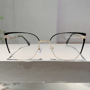 Detailed close-up of cat-eye glasses with black and gold contrast metal spring frame