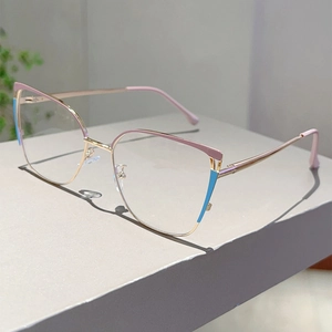 Detailed view of cat-eye glasses with gold metal frames and pink-blue color blocking