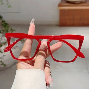 Detail of red retro full-rim glasses with acetate texture and metallic rivets