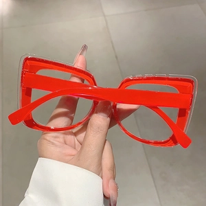 Detail of square oversized blue light glasses with dual-layer red and transparent frames