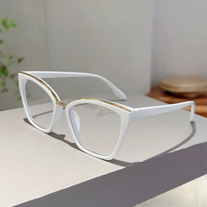 Detail of white cat-eye glasses with elegant gold metal trim on premium frame